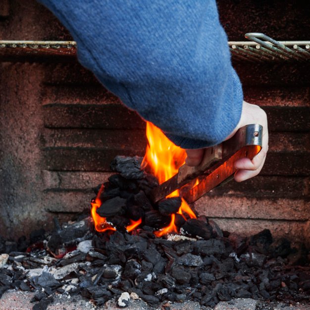 primo-piano-del-carbone-bruciante-della-mano-di-un-uomo-in-barbecue_23-2147841284.jpg